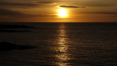 Static-shot-of-sunrise-above-the-Skagerrak-sea,-on-Justoya-island,-on-a-sunny-morning,-in-Aust-Agder,-Norway