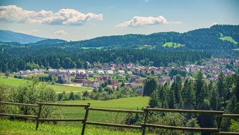 Pan-Right-View-Across-Forested-Countryside-With-Town-In-The-Distance-In-Kotlje,-Slovenia