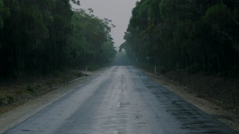 View-down-old-country-road-during-rain-storm,-rainy-weather