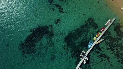 drone-shooting-with-clear-turquoise-water-of-the-Mediterranean-Sea,-the-camera-goes-up