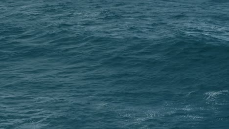 Cinematic-aerial-shot-of-dark-blue-ocean-surface,-moody-sea-waves,-deep-ocean