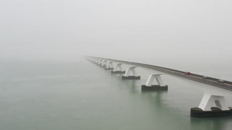 Luftaufnahme-Einer-Langen-Brücke-Zwischen-Den-Inseln-Bei-Dichtem-Nebel-In-Den-Niederlanden