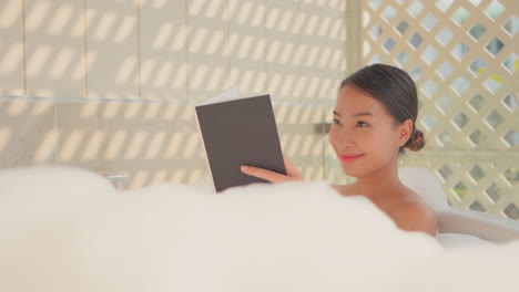 Beautiful-girl-smiling-while-read-a-book-on-luxury-bath-tub