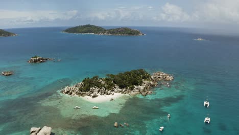Aerial:-Flying-around-Lonely-Island-with-White-Sand-Beach-and-Palms,-Seychelles