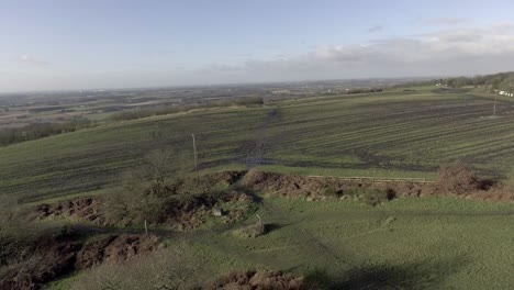 Idyllic-British-farming-meadows-countryside-fields-aerial-view-above-lush-farmland