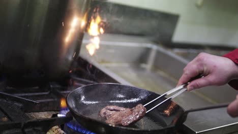 Cooking-medium-rare-steak-on-pan-in-the-kitchen-with-flames-|-SLOWMOTION