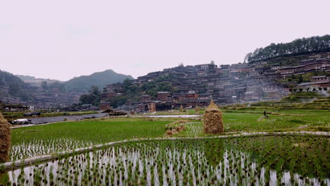 panning-shot-of-farm-fields-and-city-at-Qiandongnan,-Guizhou-province,-China,-slow-motion-high-speed