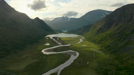 Scenic-meandering-river-flowing-through-green-valley-in-Jotunheim-park,-aerial