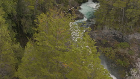 Beautiful-drone-shot-revealing-a-powerful-waterfall-behind-trees