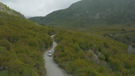 Atemberaubende-Luftaufnahme-Eines-Einsamen-Lastwagens,-Der-Durch-Eine-Dschungelstraße-In-Patagonien-Fährt