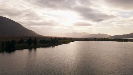 Brumoso-Amanecer-Sobre-Montañas-Doradas-Y-Un-Lago-En-Nueva-Zelanda