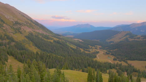 Aerial-pulling-back-over-trees-in-the-Rockies-in-Colorado-on-a-beautiful-summer-day-at-sunset-in-the-mountains