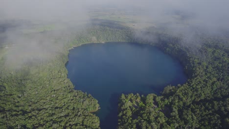 Volcanic-Lake-Eacham-With-Lush-Rainforest-In-Queensland,-Australia---aerial-shot