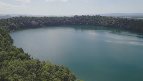 Idyllische-Landschaft-Am-Lake-Eacham-Mit-Ruhigem-Wasser-Und-üppiger-Vegetation-In-Atherton-Tableland,-Queensland,-Australien---Drohnenaufnahme