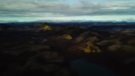 Aerial-landscape-view-over-Icelandic-highlands,-dark-hills-and-mountains,-rivers-and-lakes,-on-a-cloudy-day