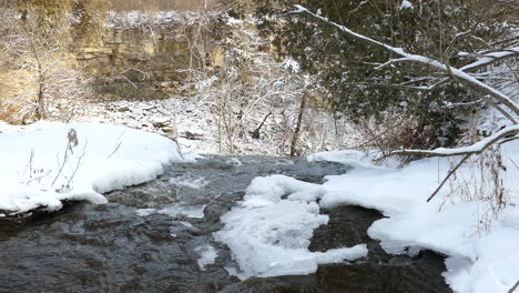 Winter-landscape-from-Niagara-Escarpment,-River-flowing-on-Frozen-Scenery,-Hamilton,-Ontario---Panning-Shot