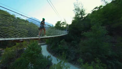 Mujer-Corriendo-En-Un-Puente-Peatonal-Suspendido-Sobre-El-Cañón-Goynuk