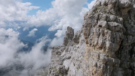 Spectacular-aerial-flyover-rocky-mountains-and-cloudy-sky-in-Brenta-Dolomites-during-sunny-day