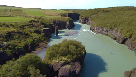 Aerial-shot-of-people-boating-in-the-silent-river-in-Iceland