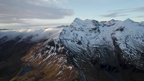 Gimbal-down-revealing-incredible-snow-capped-mountains-of-Grossglockner-at-sunset,-Austria