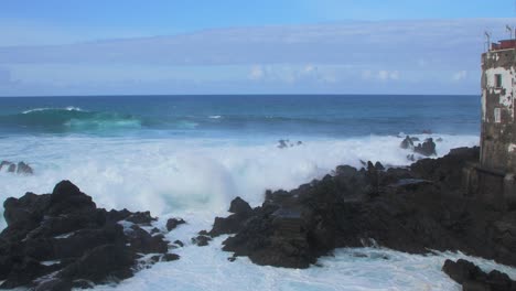Eine-Große-Welle-Des-Atlantiks-Bricht-An-Einem-Sonnigen-Tag-Während-Eines-Sturms-In-Puerto-De-La-Cruz-Auf-Den-Kanaren-An-Einer-Felsigen-Küste,-Weitwinkel-Handaufnahme