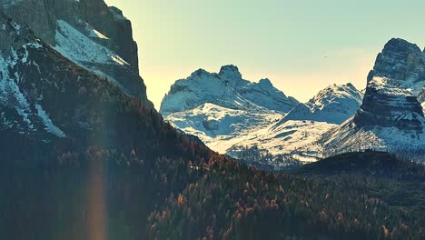 Drone-view-on-dolomites,-rocky-mountains-in-the-Italian-Alps,-with-snow-and-pine-forest-during-winter-season