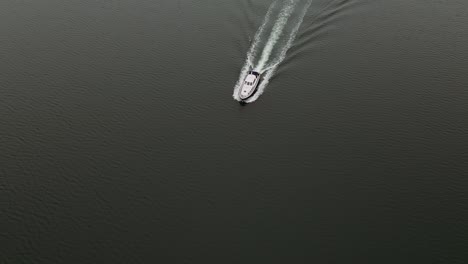Vertical-Aerial-Slow-mo-Shot-of-Boat-Cruising-along-Ocean