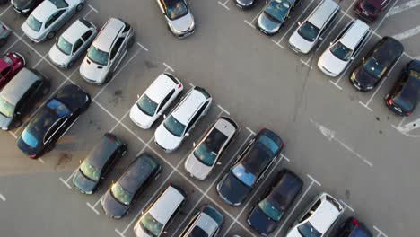Top-down-bird-eye-drone-shot-of-parking-lot-with-cars-pulling-in-and-out-of-parking-space