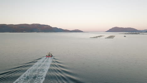 Commercial-boat-cruising-toward-marine-pens-during-golden-hour---arctic-aquafarm
