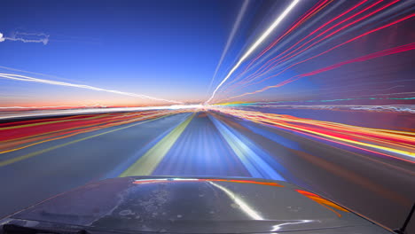 Light-trail-time-lapse-from-a-car-at-twilight-reflecting-off-the-hood-of-the-vehicle