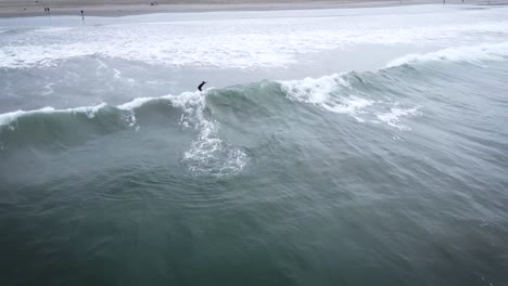 Aerial-Shot-Of-One-Surfer-Riding-Beautiful-Long-Wave-On-Sandy-Beach-,-Peru