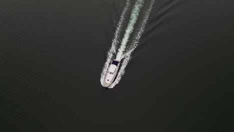 4K-Vertical-Aerial-Shot-of-Boat-Cruising-along-Ocean