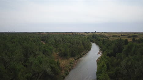 Backwards-dolly-shot-above-a-small-river-flowing-in-the-countryside-of-Georgia