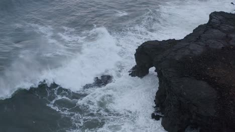 Luftaufnahme-Von-Oben-Nach-Unten-Von-Mächtigen-Meereswellen,-Die-Gegen-Felsen-Von-Island-Prallen