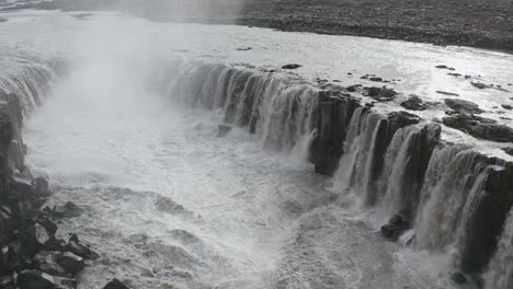 Luftaufnahme-Von-Oben-Nach-Unten-Des-Selfoss-Wasserfalls,-Der-In-Den-Jokulsa-Gletscherfluss-In-Island-Fließt