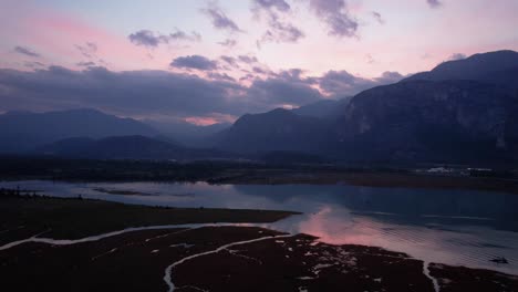 scenic-aerial-natural-sunset-at-Squamish-River-restricted-conservation-area,-panoramic-view-of-mountains-with-colourful-sky