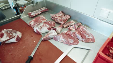Butcher-Carefully-Cutting-Lamb-Meat-On-Workbench-Wearing-Butchers-Glove-And-Placing-Them-In-Cut-Order