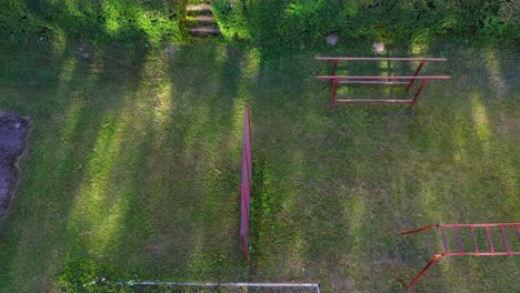 Vintage-outdoor-gym-in-local-park-on-sunny-day,-aerial-top-down-view