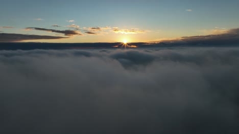Sunburst-in-vibrant-sky-at-sunrise---calming-drone-flight-above-clouds