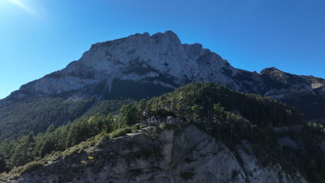 Aerial-view-rising-over-Pedroforca-pine-woodland-towards-majestic-Pyrenees-rocky-mountain-formation