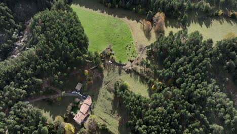 Aerial-view-descending-over-Saldes-rural-village-home-surrounded-by-green-woodland-trees-near-Pedraforca,-Catalonia