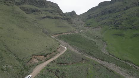 Aerial:-Tourism-vehicles-drive-rough-dirt-road-up-Sani-Pass-to-Lesotho