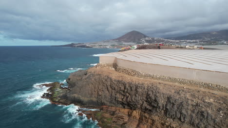 aerial-shot-revealing-the-Galdar-mountain-and-spotting-the-greenhouses-located-in-Punta-de-Galdar,-on-the-island-of-Gran-Canaria