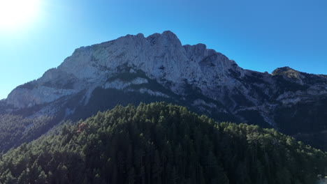 Aerial-view-climbing-over-Pedraforca-pine-forest-towards-majestic-Pyrenees-mountain-peak