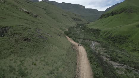 Vehículo-Resistente-Conduce-Camino-De-Tierra-áspera-Hasta-El-Hermoso-Valle-Verde-Rocoso