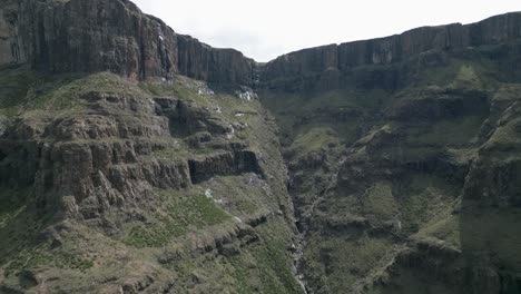 Aerial-flight-to-huge-dihedral-cleft-in-stone-escarpment-cliff