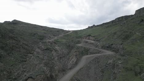 Rugged-gravel-switchback-road-leads-up-to-barren-mountain-plateau