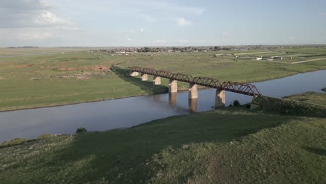 Aerial-flight-to-long-abandoned-railway-bridge-over-Vaal-River-in-ZA