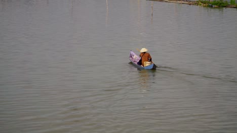 Local-fisherman-paddling-wooden-boat-in-Indonesia-across-Lake-Rawa-Pening