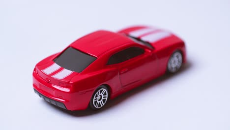 Nahaufnahme-Rotation-Eines-Modernen-Roten-Spielzeugautos-Isoliert-Auf-Weißem-Hintergrund